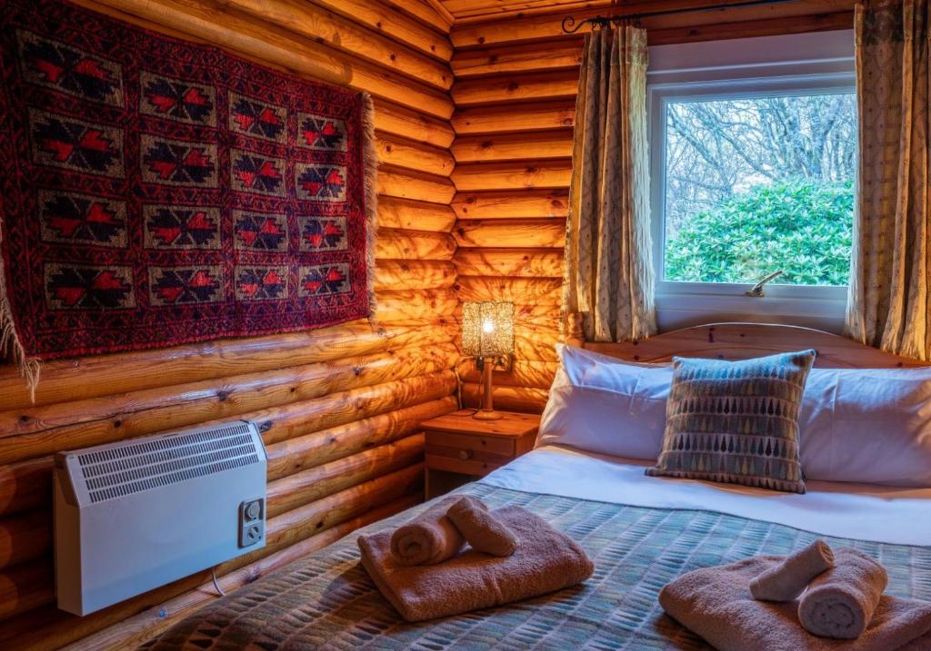 a bedroom with a bed in a log cabin at Pabay in Duirinish