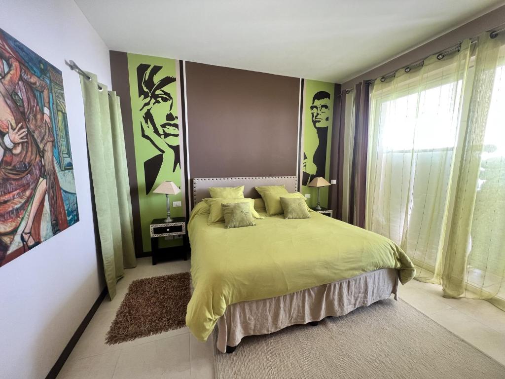a bedroom with a bed with green sheets and a window at Charming bedroom in luxurious villa with seaview in Éze