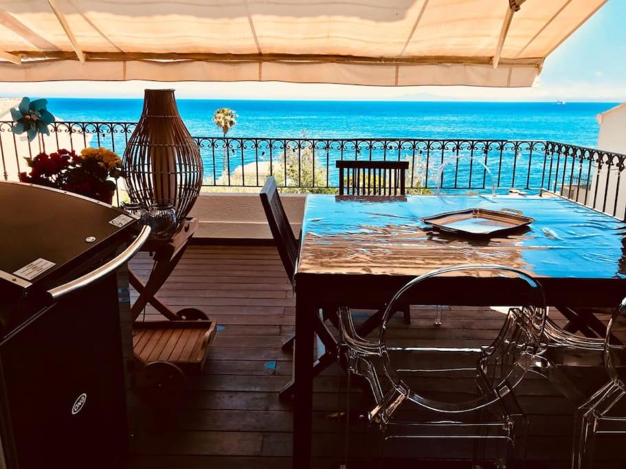 uma varanda com uma mesa e vista para o oceano em Magnifique triplex face à la Mer em San-Martino-di-Lota