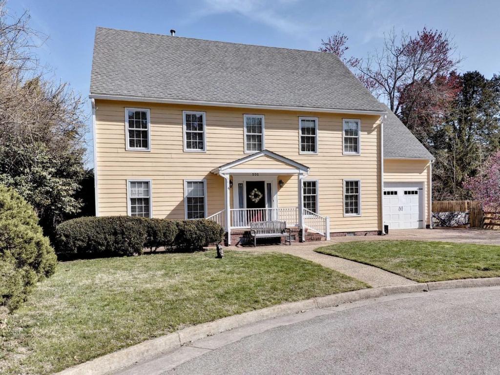 a large yellow house with a porch and a driveway at Aldrich House Bed & Breakfast in Williamsburg