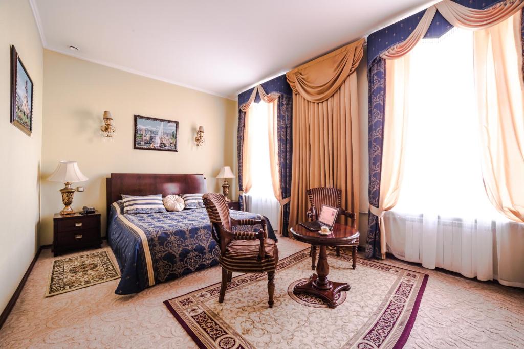 a bedroom with a bed and a table and chairs at Меблированные комнаты Ажур Классик in Saint Petersburg