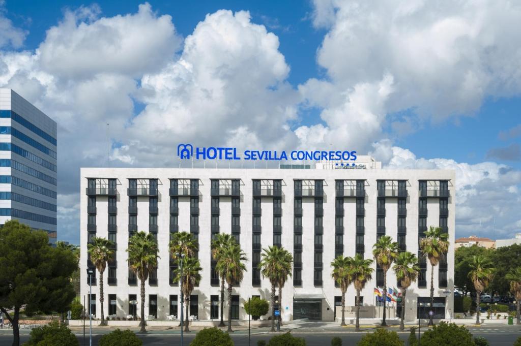 Un bâtiment blanc avec un panneau en haut dans l'établissement M.A. Hotel Sevilla Congresos, à Séville