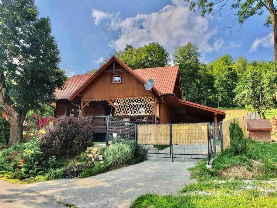 uma grande casa de madeira com uma cerca em frente em Urokliwy drewniany dom z widokiem na Tatry em Tokarnia
