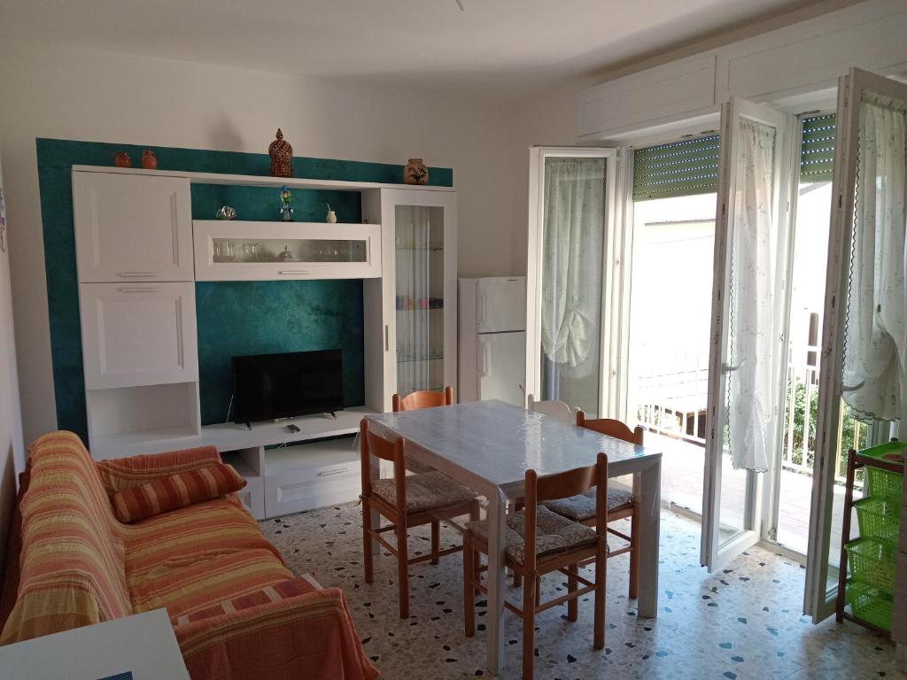 a living room with a table and a couch at Brezza Marina a 30 mt dalla spiaggia in Marina di Castagneto Carducci