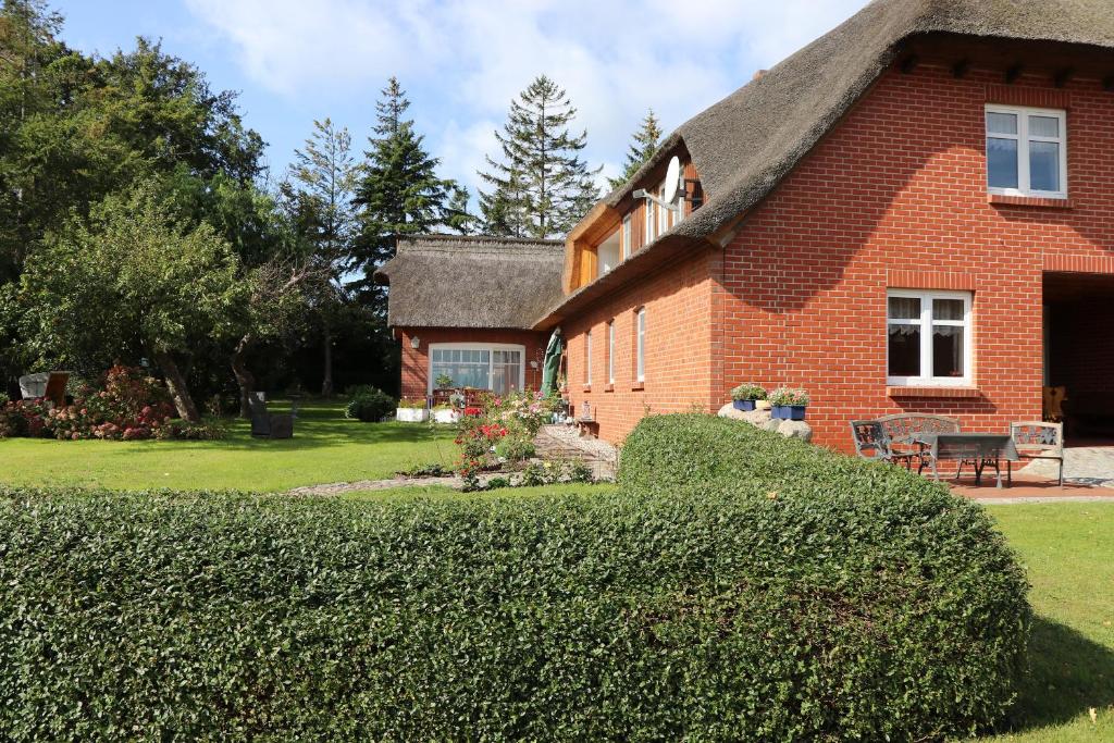 a red brick house with a thatched roof at Ferienwohnung Krull in Wustrow