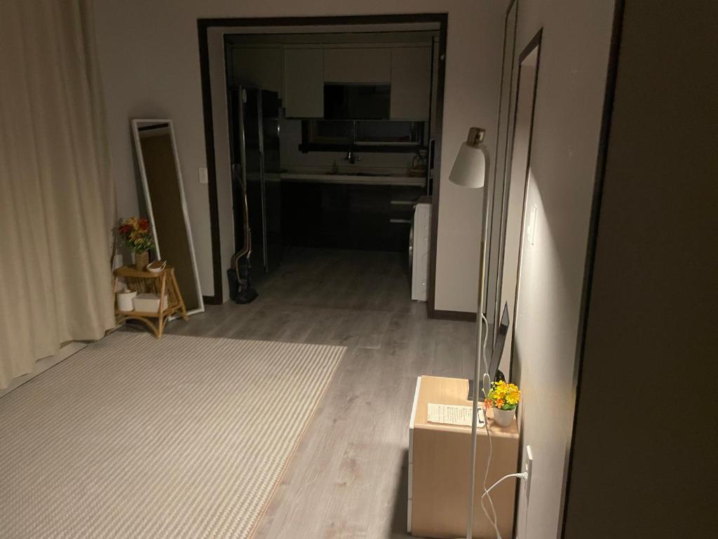una sala de estar con un pasillo con una mesa y una habitación con en Cozy Sinchon 2548 en Jeju