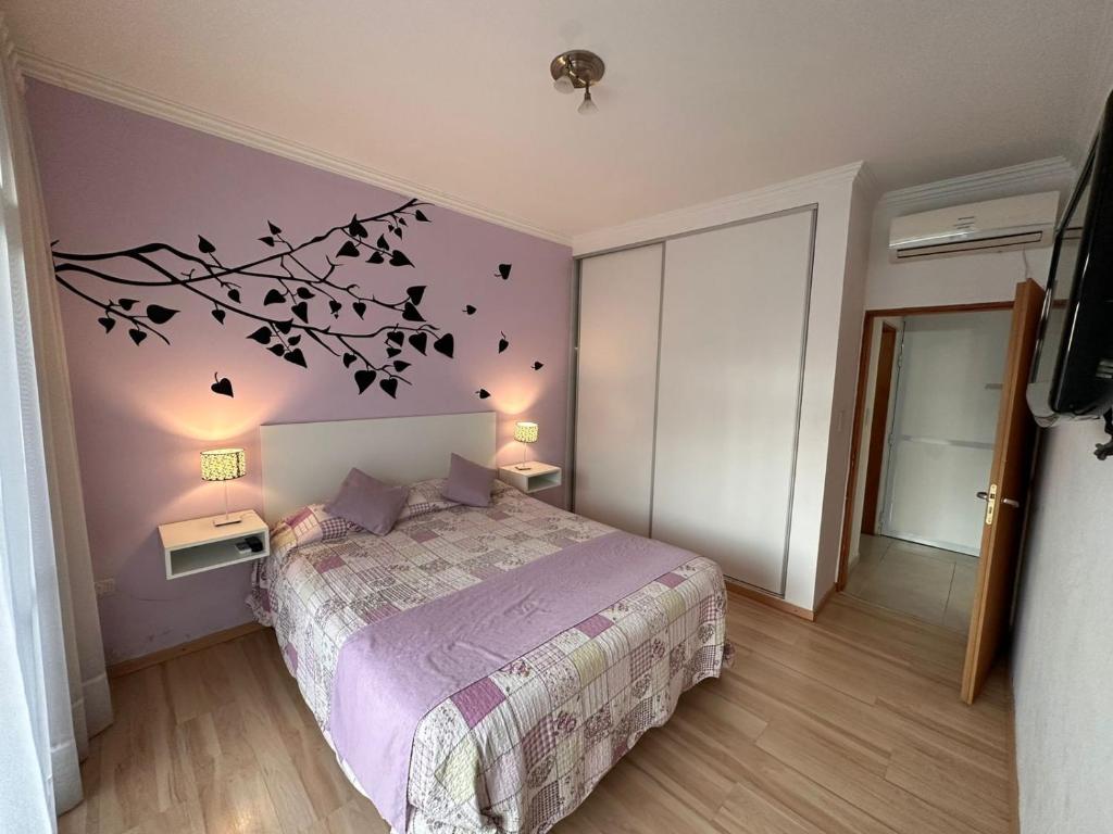 a bedroom with a bed and a tree with birds on it at Venezia Aparts in Colón