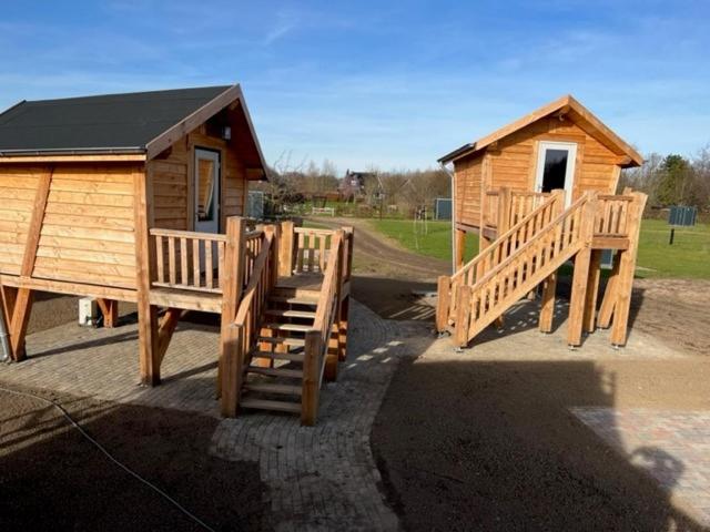 a wooden cabin with a staircase leading to it at Hoogte Huisje Schotland in Swalmen