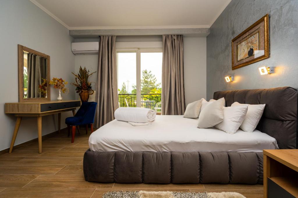 een slaapkamer met een bed, een bureau en een bank bij Hotel Epavlis in Drama