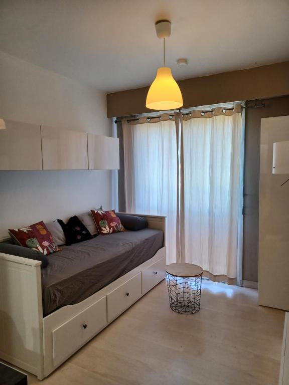 une chambre avec un grand lit avec une grande fenêtre dans l'établissement Studio à Nice avec piscine, à Nice