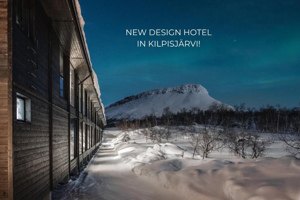 une montagne enneigée au loin avec un bâtiment dans l'établissement Santa's Hotel Rakka, à Kilpisjärvi