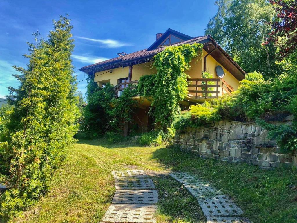 una casa con un camino de piedra delante de ella en Dom na wzgórzu - Brenna, en Brenna