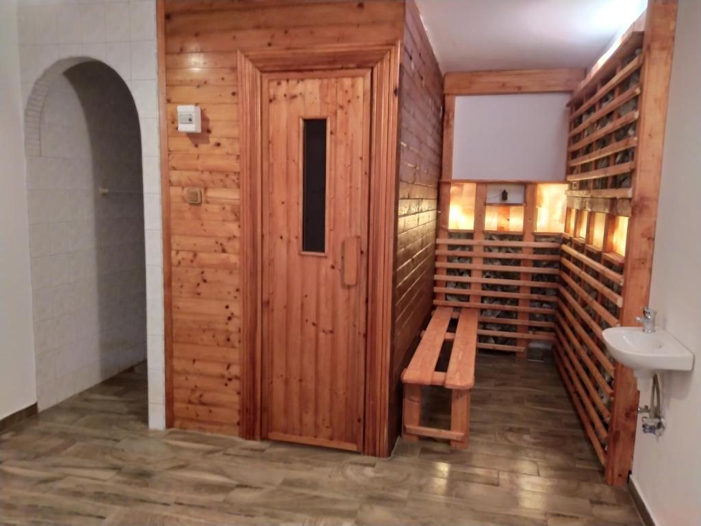 Zimmer mit einer Holztür und einer Bank in der Unterkunft Magyar Lovasvendégház in Szilvásvárad
