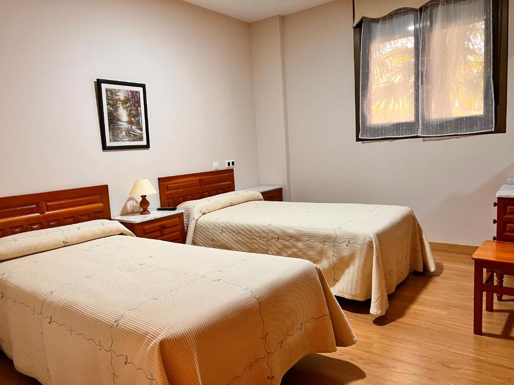 ein Hotelzimmer mit 2 Betten und einem Fenster in der Unterkunft Hostal Merindades in Villarcayo