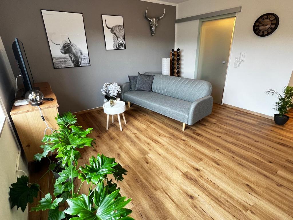 een woonkamer met een bank en houten vloeren bij Auszeit-Winterberg in Winterberg