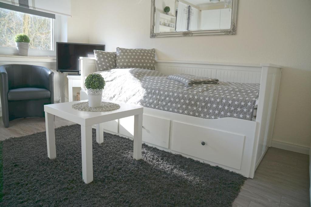 ein Schlafzimmer mit einem Bett, einem Tisch und einem Stuhl in der Unterkunft Apartmenthaus Frauenpreis FeWo 61 in Cuxhaven