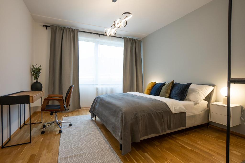 1 dormitorio con cama, escritorio y ventana en Bright stylish apartment in a top location, en Viena