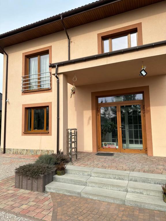 una casa con una escalera delante de una puerta en Villa Speranza Kościelna Droga 12, en Łomianki Dolne