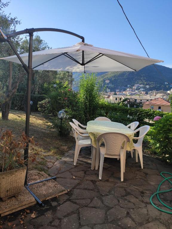 stół i krzesła pod białym parasolem w obiekcie CASA GAIA - Limoncello - parcheggio privato incluso w mieście Levanto