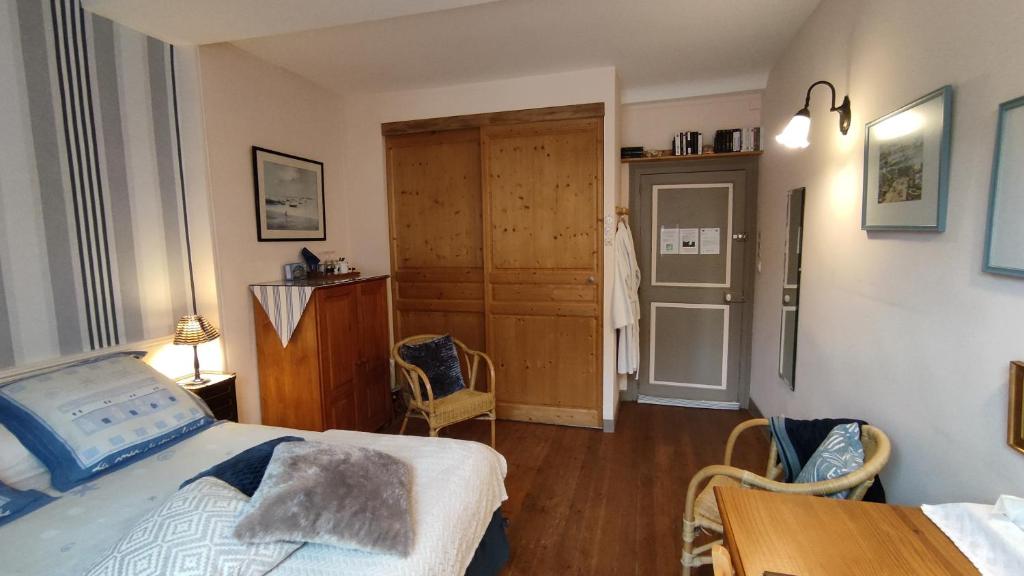 a bedroom with a bed and a table and chairs at Chambre d&#39;hôtes - Dodo et tartines in Bayeux