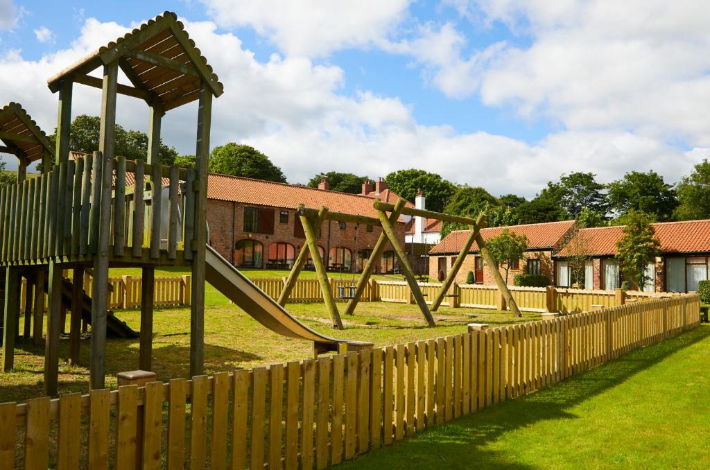 a playground with a slide in a park at Filey Holiday Cottages in Filey