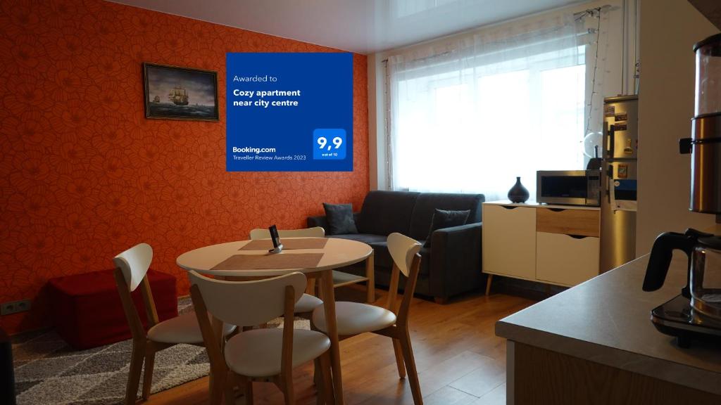 Cozy Telliskivi apartment near city centre في تالين: غرفة مع طاولة وكراسي وغرفة معيشة
