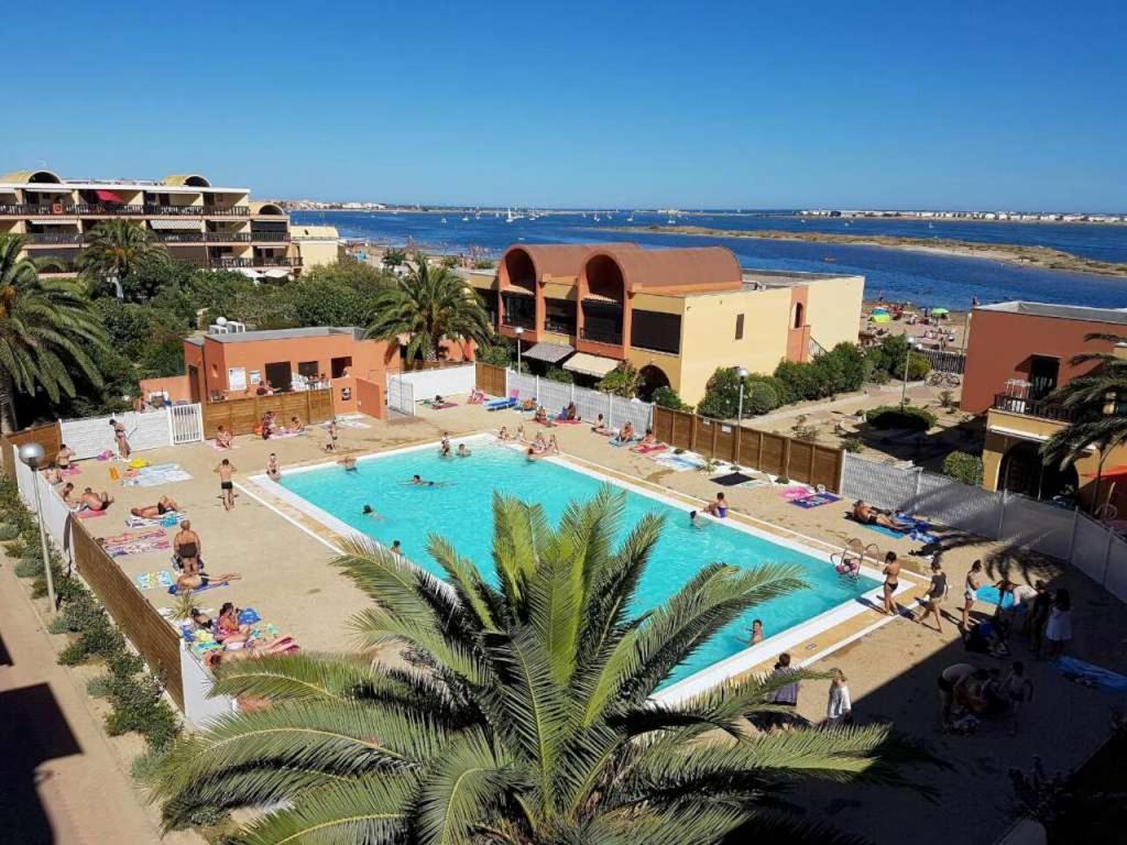 une vue aérienne d'une piscine dans un complexe hôtelier dans l'établissement Gruissan studio aux Amarines au bord de la plage du Grazel, à Gruissan
