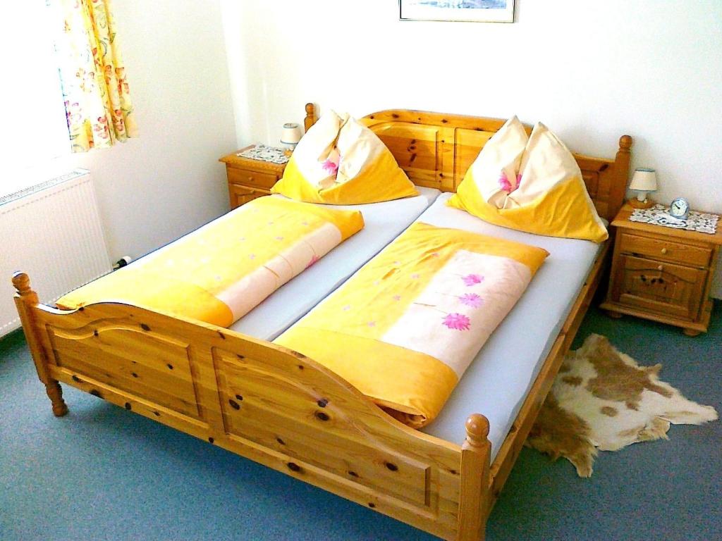 2 Betten in einem Schlafzimmer mit gelber und orangefarbener Bettwäsche in der Unterkunft Libiseller Anita Biobauernhof UNTERHUB in Taxenbach