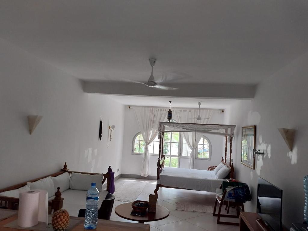 sala de estar con cama y sofá en Ground floor apartment Simba Village, Diani, en Ukunda