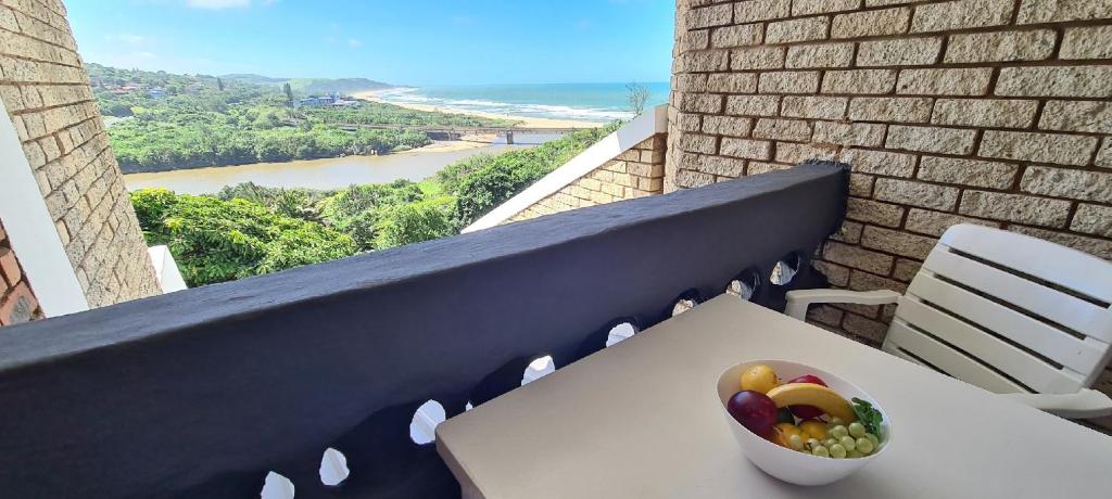 a bowl of fruit sitting on a table on a balcony at Pearly Shells in Scottburgh