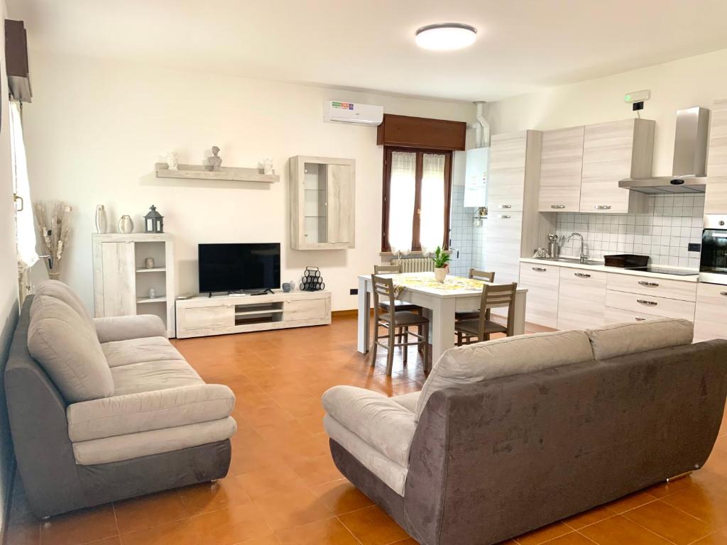 - un grand salon avec un canapé et une table dans l'établissement La Cicala - appartamento con giardino privato, à Rivoli Veronese