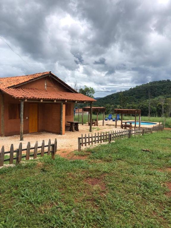 um edifício com uma cerca ao lado de uma piscina em Recanto do Vale em Pirenópolis