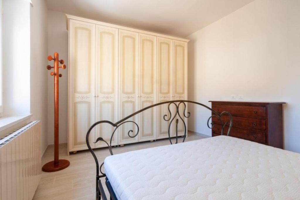 a bedroom with a bed and a wooden dresser at Appartamenti PEN in Follonica