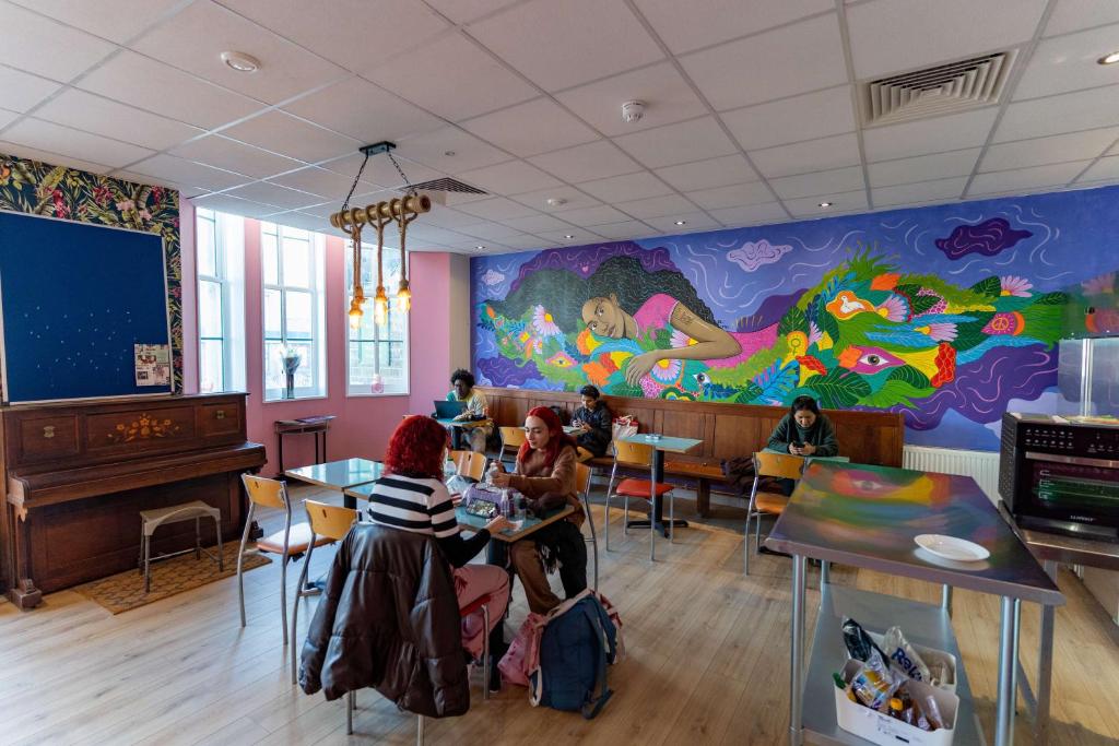 a group of people sitting at tables in a restaurant at Hostelle - women only hostel London in London