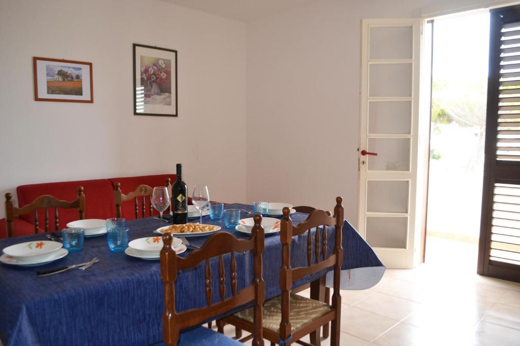 uma mesa de jantar com uma toalha de mesa azul em Apt 7 Posti Vicino Spiaggia em San Foca