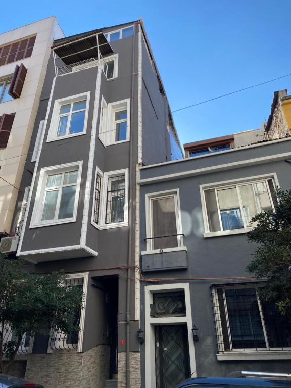 a gray building with windows on a city street at NOBIS Cihangir Apartments in Istanbul