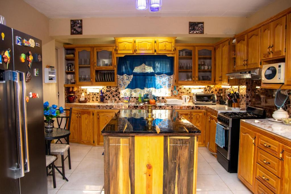 a kitchen with wooden cabinets and a island in it at PRI Guest House in Arnos Vale