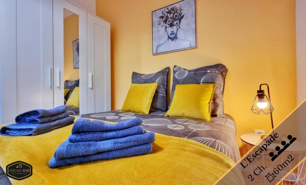 1 dormitorio con 1 cama grande con almohadas azules y amarillas en Les Appartements Neppert - Calme - Spacieux - Fibre - RBNB, en Mulhouse