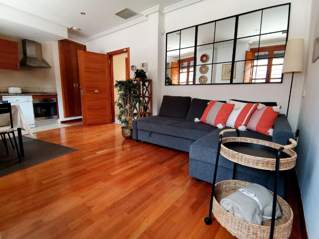 salon z niebieską kanapą i drewnianą podłogą w obiekcie Apartamento El Rincón de Sancha w mieście Toledo