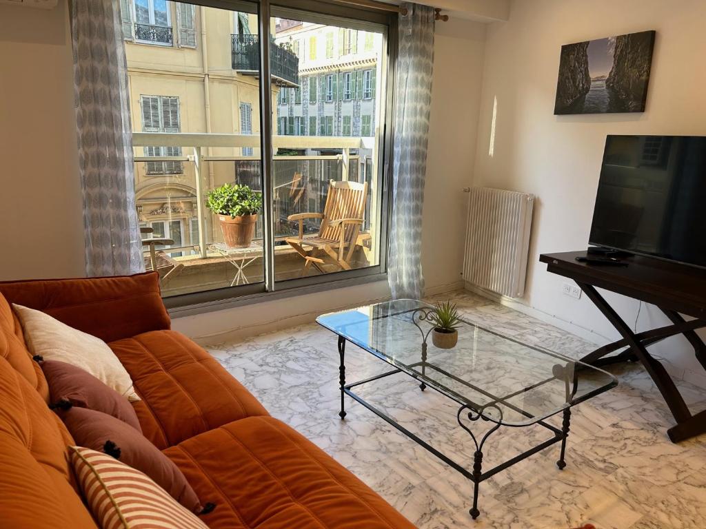 un salon avec un canapé et une table en verre dans l'établissement Nice la Belle, city centre 1 bed, 2 terrace, quiet, à Nice