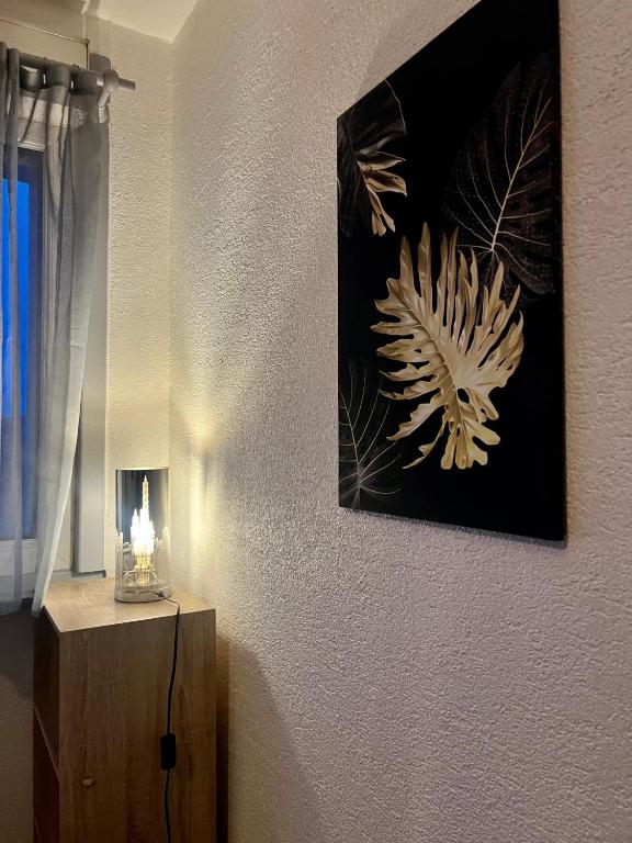 a room with a picture on the wall and a lamp at Cocon Accès facile Parking Gratuit in Belfort