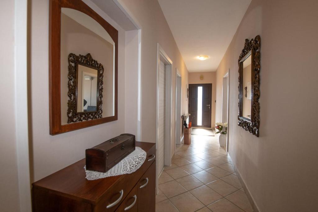 a hallway with a mirror and a toaster on a dresser at Apartman Elvis in Lovran