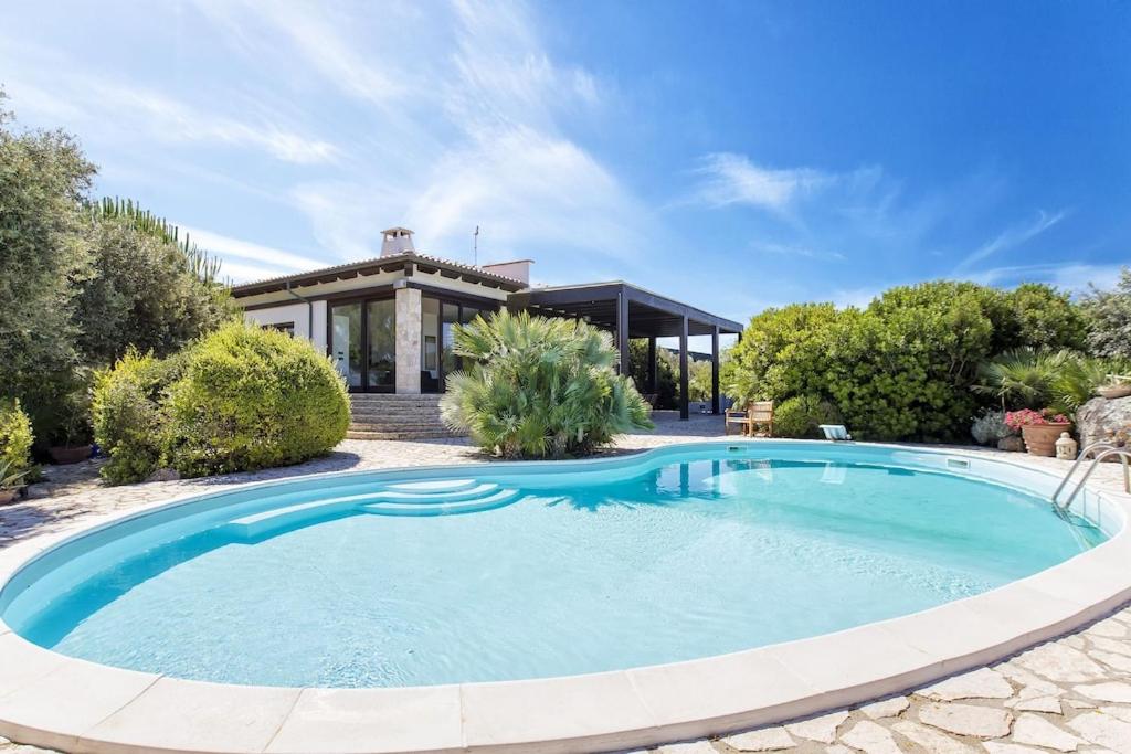 une grande piscine devant une maison dans l'établissement ClickSardegna Villa Paraiba fronte mare per 12 persone, à Alghero