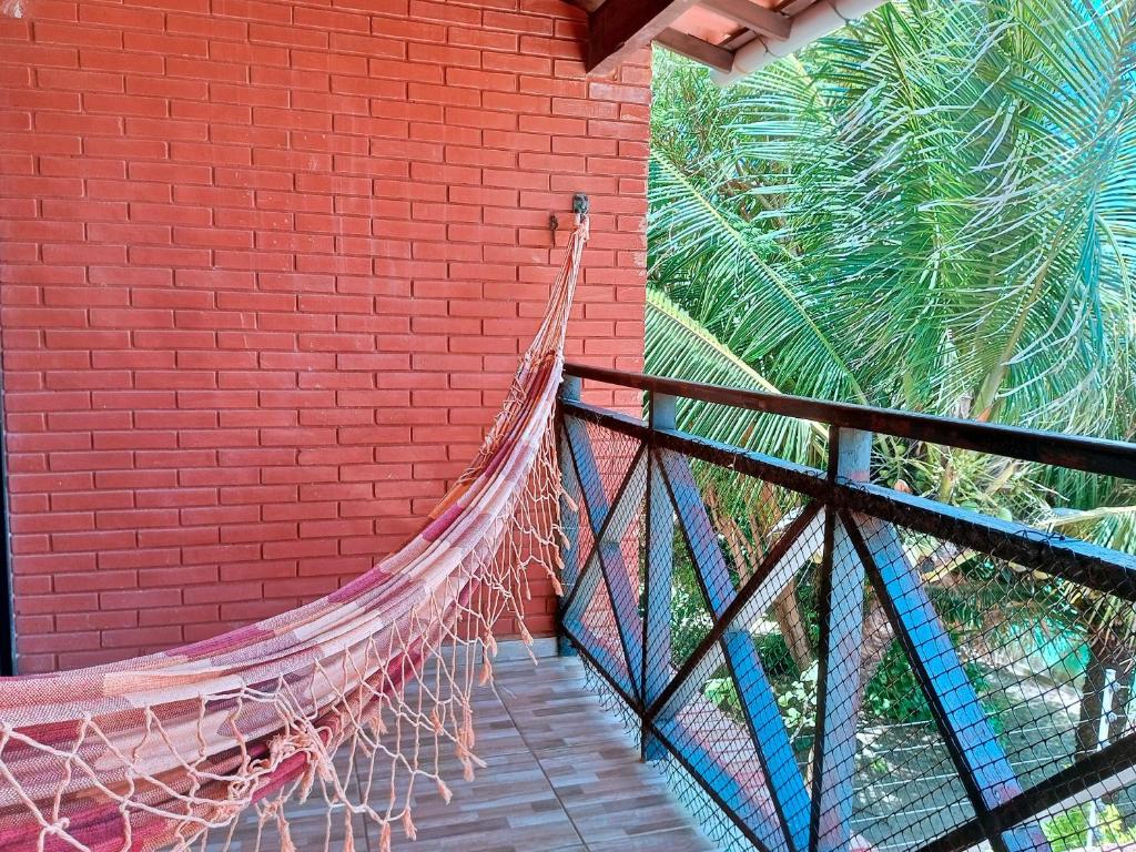 a hammock hanging from a brick wall next to a building at Conforto 100 mts da praia in Barra de São Miguel