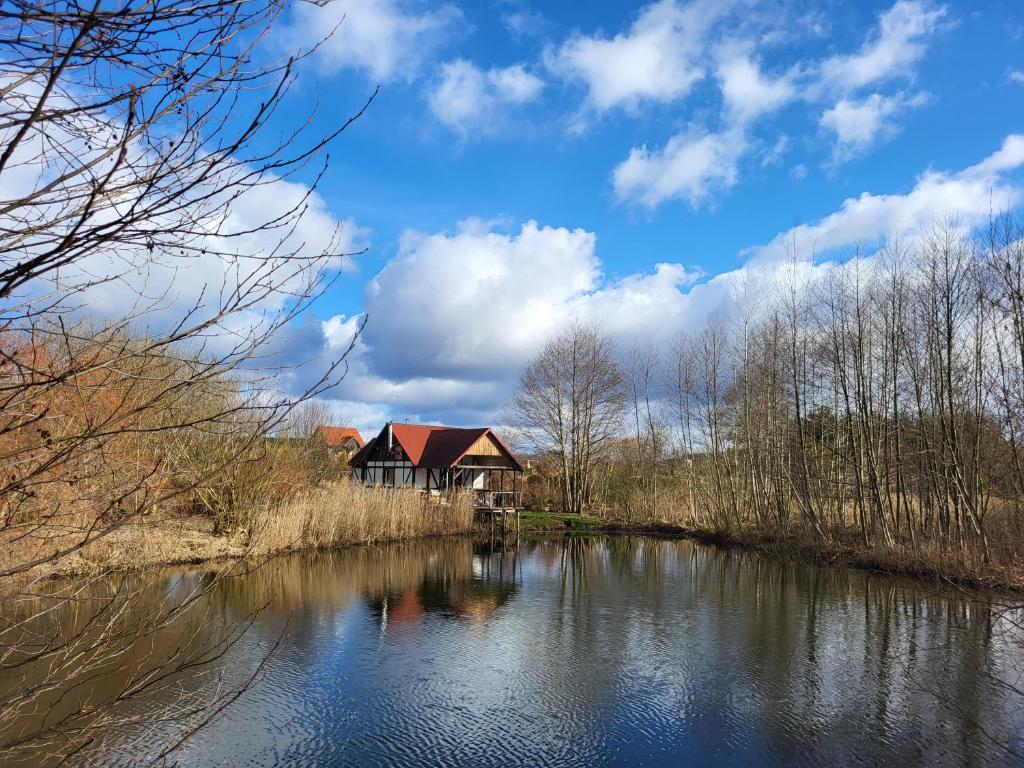 ein Haus am Ufer eines Flusses in der Unterkunft Dom Rybaka in Mirosławiec