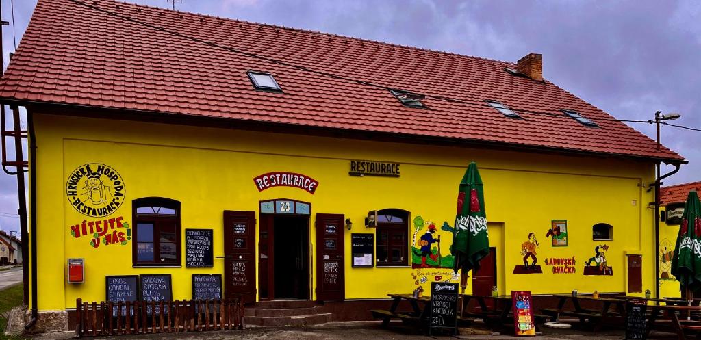 a yellow building with a red roof at Hrusická restaurace a penzion in Hrusice