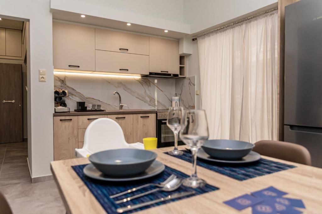 a kitchen with a table with two bowls and wine glasses at P&K LUXURY APARTMENTS 2 in Kalamata