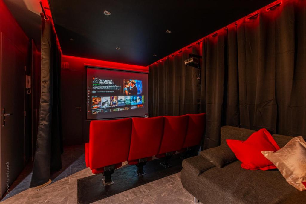 una sala de cine con sillas rojas y TV en The Movies - Fairytale Factory, en Montévrain