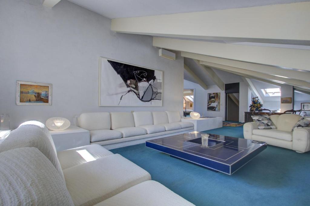 een woonkamer met witte meubels en een tafel bij ARNOLDI-Rooftop in Venetië