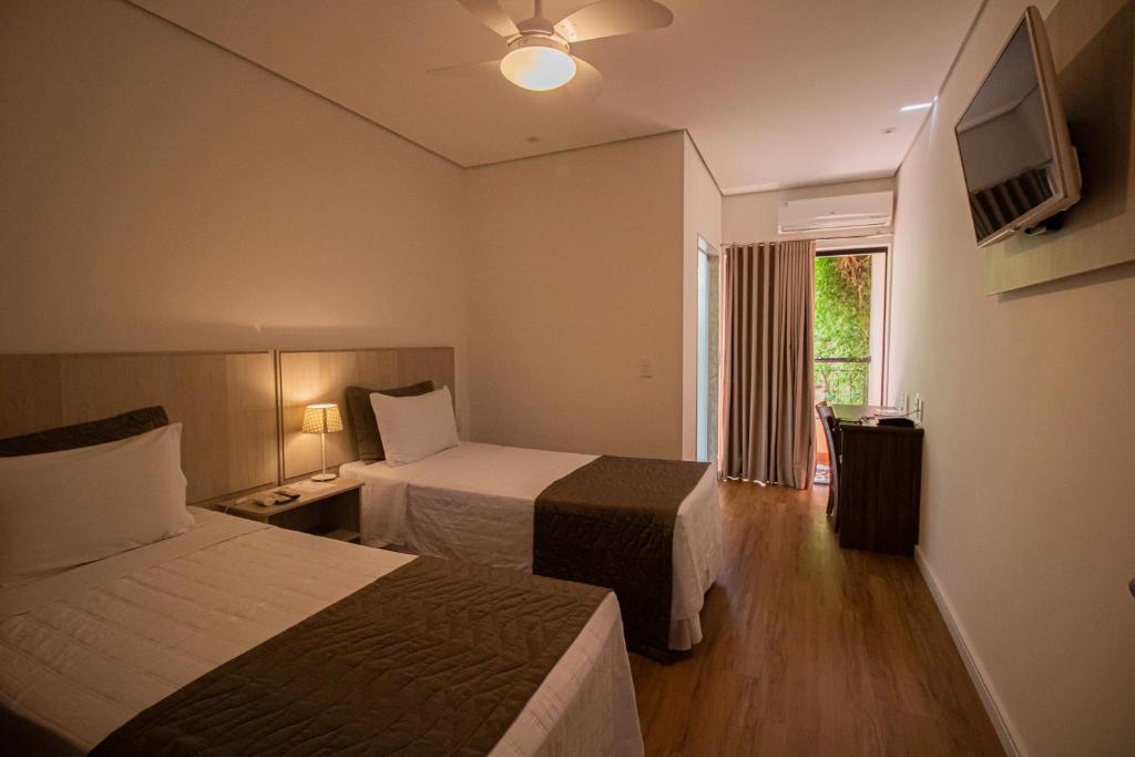 Habitación de hotel con 2 camas y TV en Prado Hotel, en Amparo
